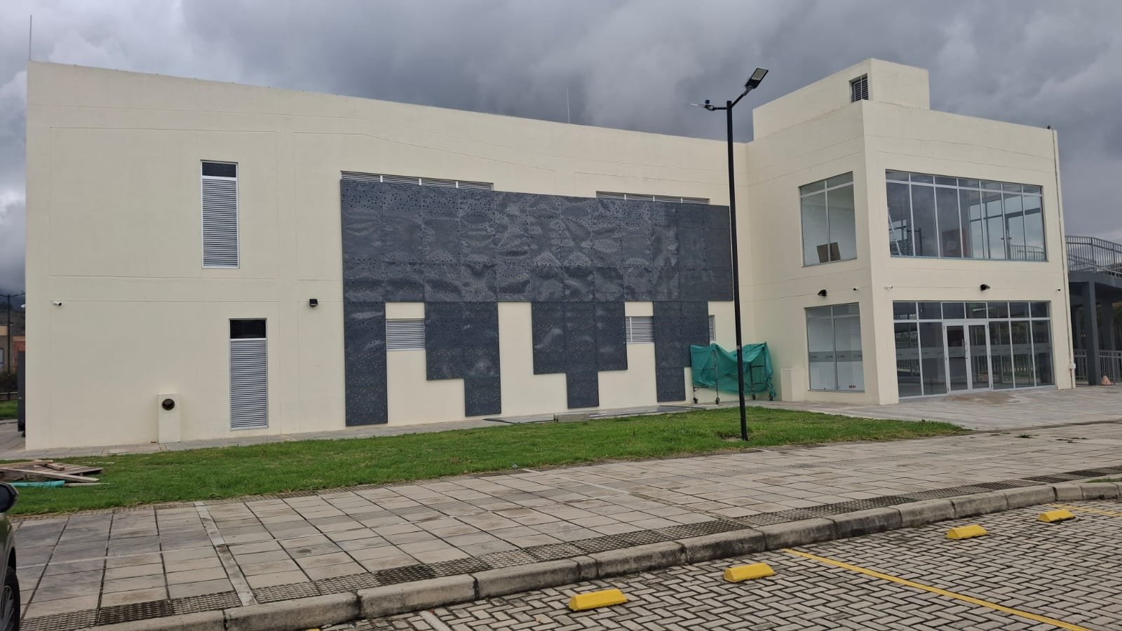 Fachada institucional terminada con ventanería y elementos metálicos